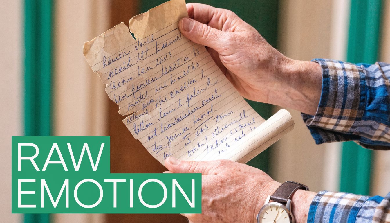A close-up view of an elderly person holding a weathered, handwritten note with cursive script.