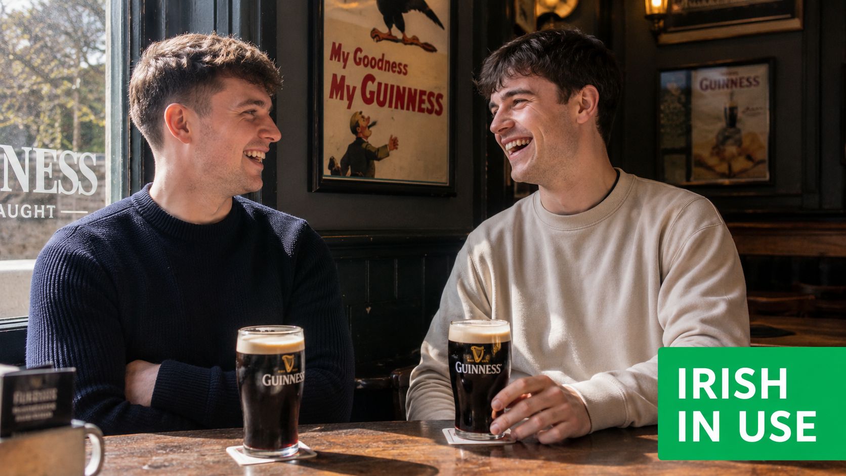 Two young men laughing and sharing a Guinness beer together in a traditional Irish pub.