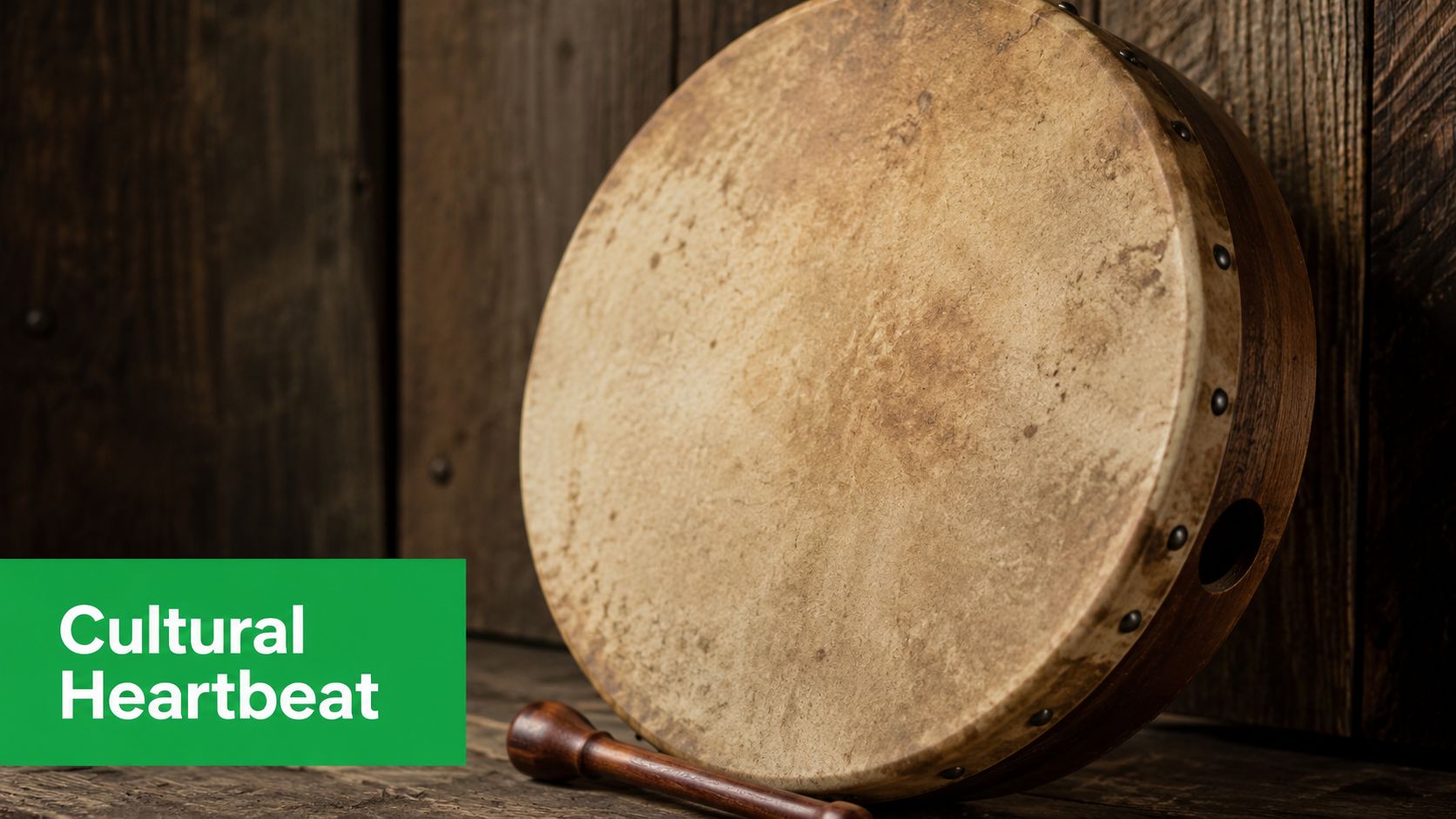 A traditional Irish bodhran drum with a wooden beater resting against a rustic wooden wall background.