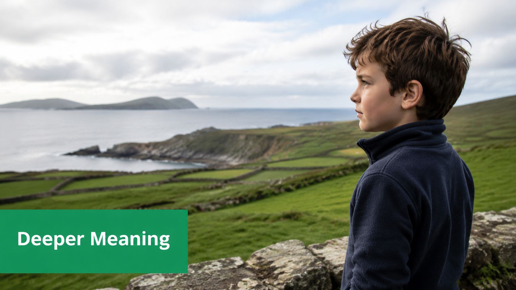 A young boy standing outdoors looking at a beautiful green coastal landscape in Ireland.