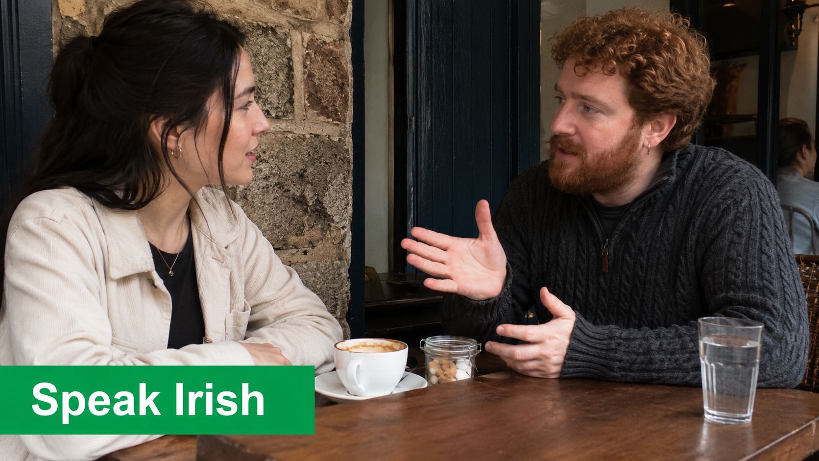 A woman and a man sitting at a table in a cafe having a friendly conversation.