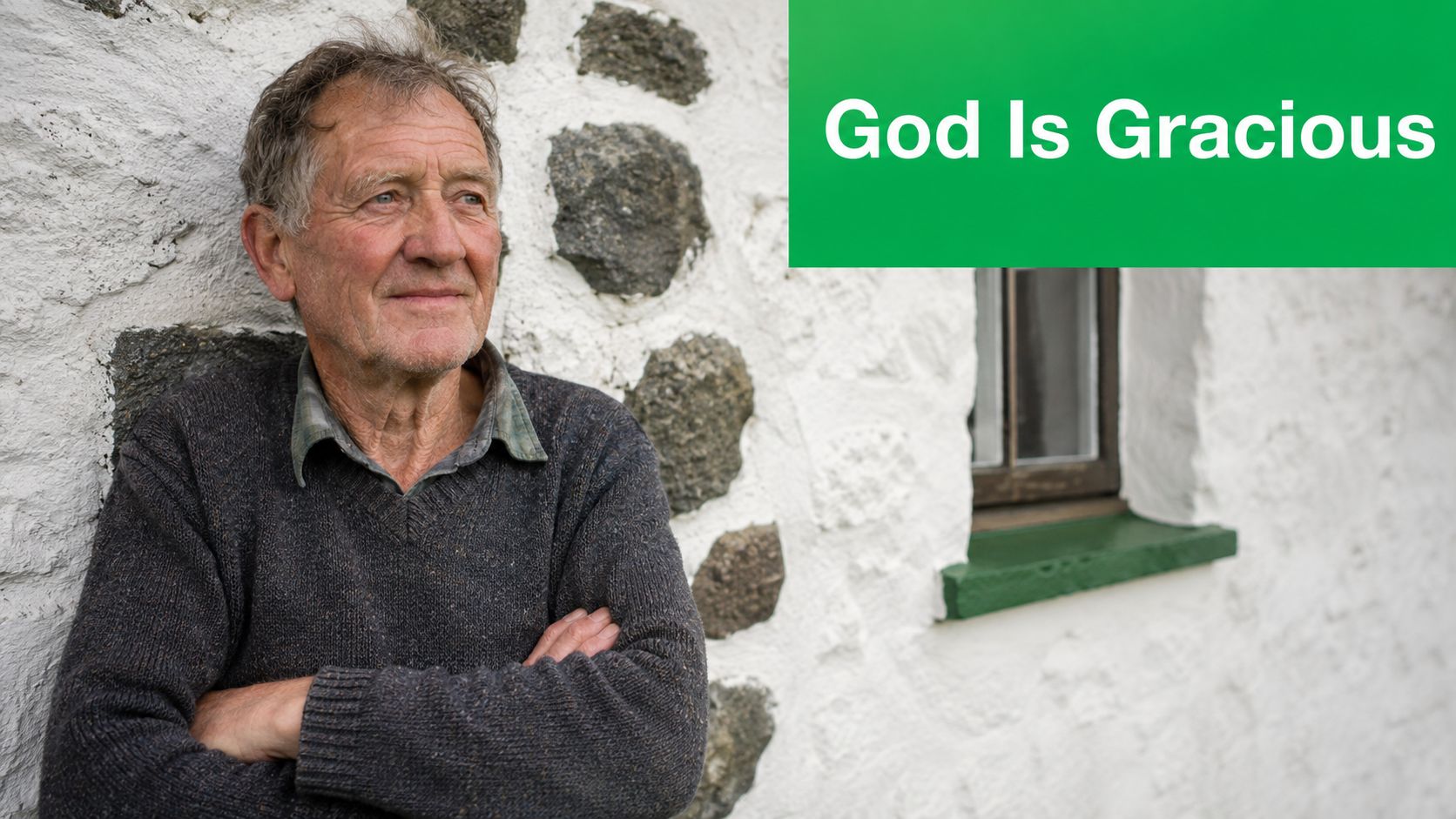 An older Irish man with a kind expression standing outdoors against a traditional white stone wall.